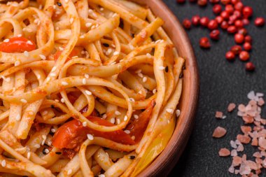 Sebzeli, mantarlı, tuzlu ve baharatlı lezzetli Asya udonu tabağı koyu beton arka planda.