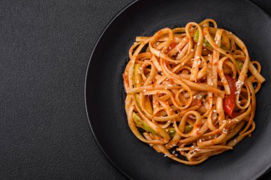 Sebzeli, mantarlı, tuzlu ve baharatlı lezzetli Asya udonu tabağı koyu beton arka planda.