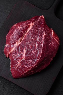 Taze çiğ biftek, tuz, baharat ve çimento üzerine otlar.