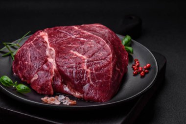 Taze çiğ biftek, tuz, baharat ve çimento üzerine otlar.