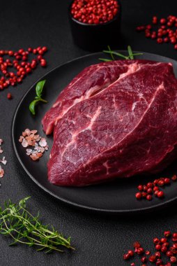 Taze çiğ biftek, tuz, baharat ve çimento üzerine otlar.