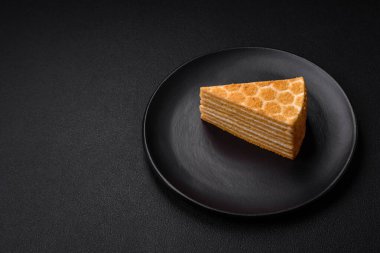 Lezzetli, tatlı, ballı pasta, beyaz kremalı, desenli beton arka plan.