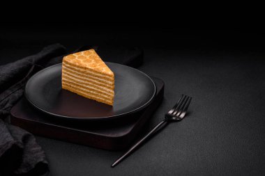 Lezzetli, tatlı, ballı pasta, beyaz kremalı, desenli beton arka plan.