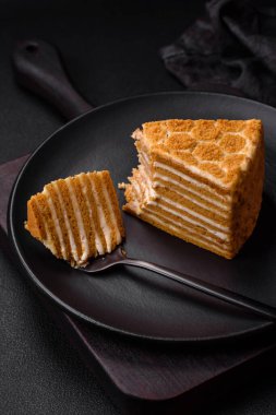 Lezzetli, tatlı, ballı pasta, beyaz kremalı, desenli beton arka plan.