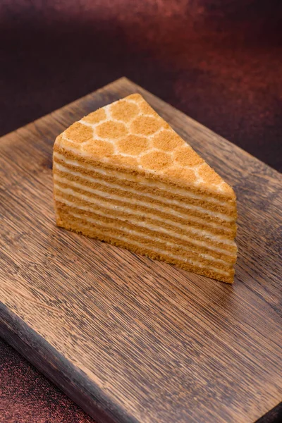 質感のコンクリートの背景に白いクリームとおいしい新鮮な甘い蜂蜜ケーキ層ケーキ — ストック写真
