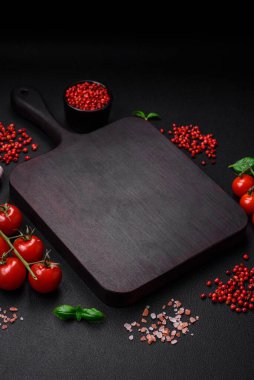 Koyu beton zeminde domates, tuz, baharat ve otlar pişirmek için gerekli malzemeler.