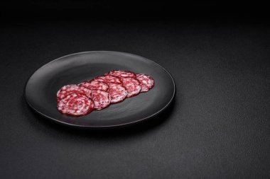 Lezzetli füme sosis, domuz pastırması, tuz, baharat ve ağaç kesme tahtasında dilimlenmiş otlar.