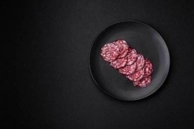 Lezzetli füme sosis, domuz pastırması, tuz, baharat ve ağaç kesme tahtasında dilimlenmiş otlar.