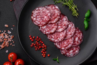 Lezzetli füme sosis, domuz pastırması, tuz, baharat ve ağaç kesme tahtasında dilimlenmiş otlar.