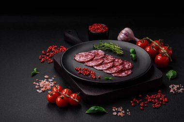 Lezzetli füme sosis, domuz pastırması, tuz, baharat ve ağaç kesme tahtasında dilimlenmiş otlar.