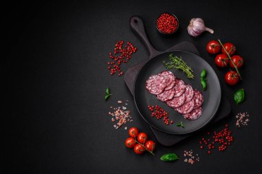 Lezzetli füme sosis, domuz pastırması, tuz, baharat ve ağaç kesme tahtasında dilimlenmiş otlar.