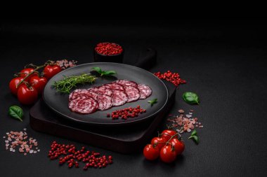 Lezzetli füme sosis, domuz pastırması, tuz, baharat ve ağaç kesme tahtasında dilimlenmiş otlar.