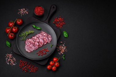 Lezzetli füme sosis, domuz pastırması, tuz, baharat ve ağaç kesme tahtasında dilimlenmiş otlar.