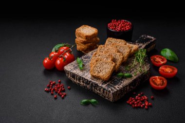 Lezzetli tuzlu dikdörtgen buğday ekmeği. Koyu beton arka planda tuz ve baharatlarla.