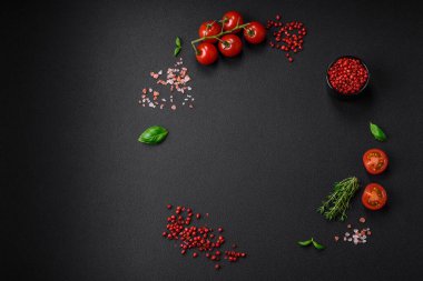 Koyu beton zeminde domates, tuz, baharat ve otlar pişirmek için gerekli malzemeler.