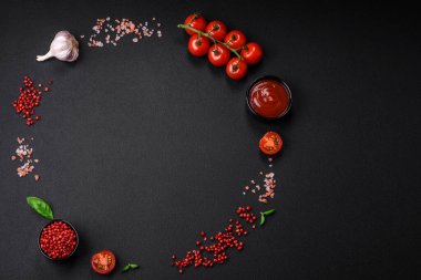 Koyu beton zeminde domates, tuz, baharat ve otlar pişirmek için gerekli malzemeler.