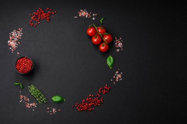 Koyu beton zeminde domates, tuz, baharat ve otlar pişirmek için gerekli malzemeler.