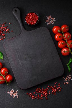 Koyu beton zeminde domates, tuz, baharat ve otlar pişirmek için gerekli malzemeler.