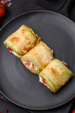 Lezzetli sağlıklı vejetaryen sebze rulosu kabak, domates, biber ve baharatlı ve çimento kaplı bir sos.