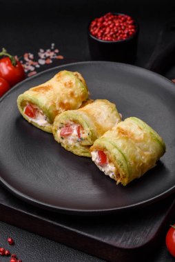 Lezzetli sağlıklı vejetaryen sebze rulosu kabak, domates, biber ve baharatlı ve çimento kaplı bir sos.
