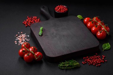 Koyu beton zeminde domates, tuz, baharat ve otlar pişirmek için gerekli malzemeler.