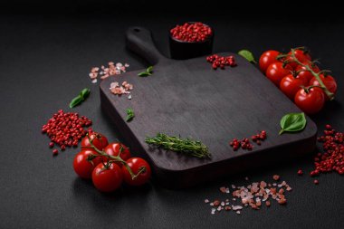 Koyu beton zeminde domates, tuz, baharat ve otlar pişirmek için gerekli malzemeler.