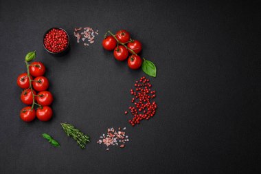 Koyu beton zeminde domates, tuz, baharat ve otlar pişirmek için gerekli malzemeler.