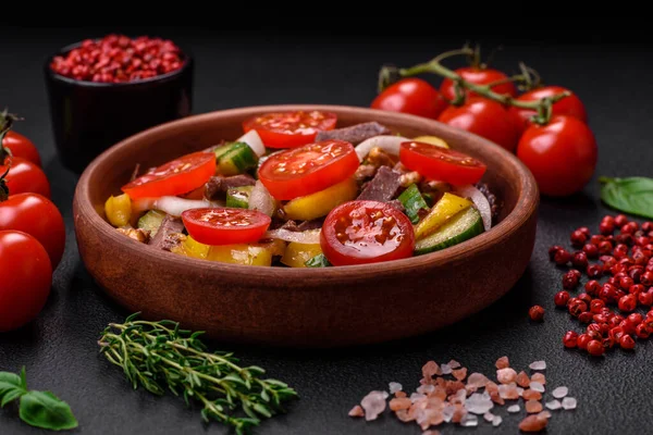 stock image Delicious fresh salad with beef slices, cherry tomatoes, sweet peppers, salt, spices and herbs on a textured concrete background