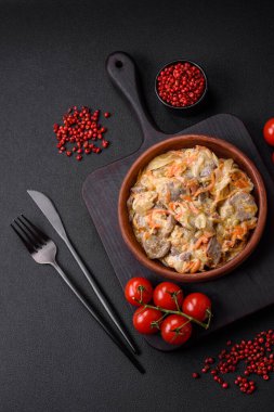 Lezzetli haşlanmış biftek ya da havuç, soğan, ekşi krema ve baharatlı seramik tabakta dilimlenmiş domuz dili.