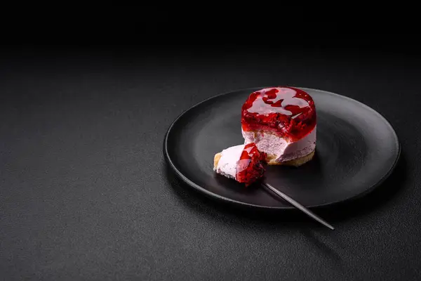 stock image Delicious fresh sweet cheesecake cake with berries and red color jelly on a dark concrete background