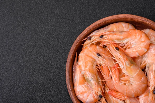 stock image Delicious fresh boiled tiger prawns with salt and spices on a ceramic plate on a dark concrete background