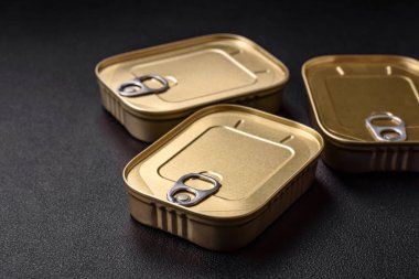 Teneke ya da alüminyum dikdörtgen konserve kutusu ve koyu beton arka planda bir anahtar.