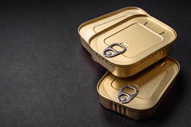 Teneke ya da alüminyum dikdörtgen konserve kutusu ve koyu beton arka planda bir anahtar.