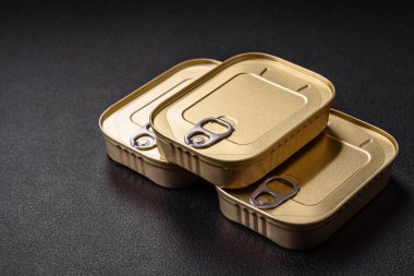 Teneke ya da alüminyum dikdörtgen konserve kutusu ve koyu beton arka planda bir anahtar.