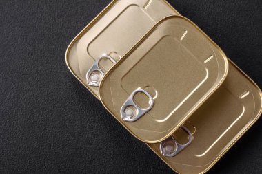 Teneke ya da alüminyum dikdörtgen konserve kutusu ve koyu beton arka planda bir anahtar.