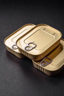 Teneke ya da alüminyum dikdörtgen konserve kutusu ve koyu beton arka planda bir anahtar.