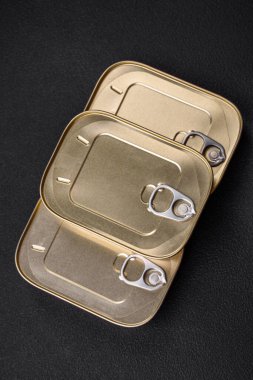 Teneke ya da alüminyum dikdörtgen konserve kutusu ve koyu beton arka planda bir anahtar.