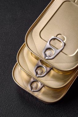 Teneke ya da alüminyum dikdörtgen konserve kutusu ve koyu beton arka planda bir anahtar.