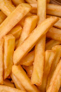 Lezzetli çıtır patates kızartması. Koyu beton bir arka planda karton bir kutuda tuz ve baharatla.