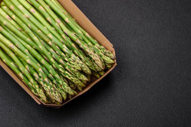 Koyu dokulu arka planda nefis taze kuşkonmaz filizleri. Sağlıklı bir vejetaryen yemeği.