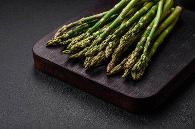 Koyu dokulu arka planda nefis taze kuşkonmaz filizleri. Sağlıklı bir vejetaryen yemeği.