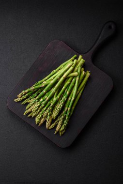 Koyu dokulu arka planda nefis taze kuşkonmaz filizleri. Sağlıklı bir vejetaryen yemeği.