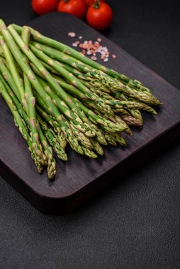 Koyu dokulu arka planda nefis taze kuşkonmaz filizleri. Sağlıklı bir vejetaryen yemeği.