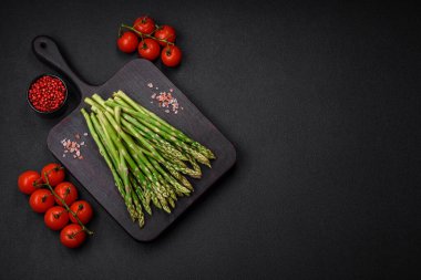 Koyu dokulu arka planda nefis taze kuşkonmaz filizleri. Sağlıklı bir vejetaryen yemeği.