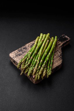 Koyu dokulu arka planda nefis taze kuşkonmaz filizleri. Sağlıklı bir vejetaryen yemeği.