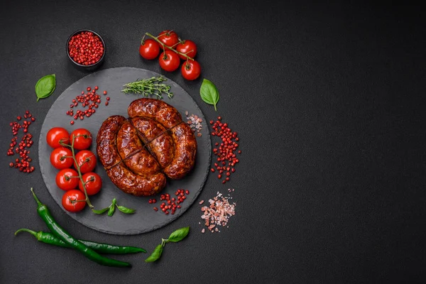 stock image Delicious grilled sausage in the form of a ring with salt, spices and herbs on a dark concrete background