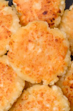 Kuru üzümlü ve vanilyalı lezzetli süzme peynirli kekler. Siyah seramik tabakta, koyu beton arka planda.