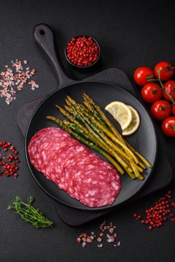 Dilimlenmiş sosis, kuşkonmaz, tuz, baharat ve otlardan oluşan lezzetli besleyici bir kahvaltı.