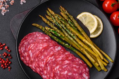 Dilimlenmiş sosis, kuşkonmaz, tuz, baharat ve otlardan oluşan lezzetli besleyici bir kahvaltı.