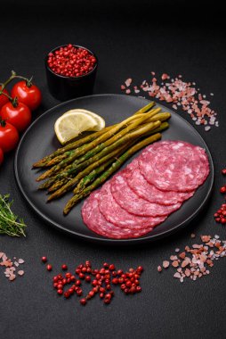 Dilimlenmiş sosis, kuşkonmaz, tuz, baharat ve otlardan oluşan lezzetli besleyici bir kahvaltı.